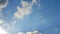 Time lapse of beautiful white fluffy clouds moved by the wind in a deep blue summer sky