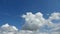 Time lapse of beautiful white fluffy clouds moved by the wind in a deep blue summer sky