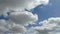 Time lapse of beautiful white fluffy clouds moved by the wind in a deep blue summer sky