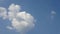 Time lapse of beautiful white fluffy clouds moved by the wind in a deep blue summer sky