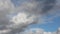 Time lapse of beautiful white fluffy clouds moved by the wind in a deep blue summer sky