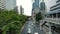 Time-lapse Car traffic on the avenue, sidewalk, Skytrain over the road lines and skyscrapers