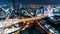 Time-lapse of car traffic transportation on highway road, toll gate at night. Cityscape view with construction crane on building