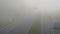 Time-lapse of cars moving along the road in dense fog