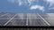 Time lapse of cloud reflections on solar panels on a black tile roof