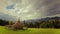 Time lapse clouds moving over beautiful mountain landscape with hay stack