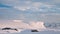 Time lapse of clouds run over icebergs mountain ranges aerial. Wild scene of snowy and icy mount peak