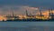 Time lapse of clouds and sky over shipping and cargo facilities along glistening Singapore Straits at sunset 4k