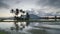 Time lapse cloudy morning with with coconut trees reflect in the water