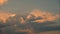 Time-lapse dark cumulus and pink cirrus clouds move across evening sky at dusk