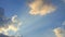 Time lapse of dazzling sun ray shine through white fluffy cloud on bright sunny day with blue sky