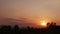 Time lapse of evening golden sky cloudscape turn red-orange shade sunset, the sun goes down below the horizon behide mountains and