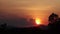 Time lapse of evening golden sky cloudscape turn red-orange shade sunset, the sun goes down below the horizon behide mountains and