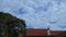 time lapse Fast moving clouds against a nice blue sky with a red roof suburban house Sydney NSW Australia