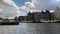 Time lapse footage of people riding boats on Amstel river in Amsterdam. Historical and traditional buildings