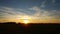 Time lapse footage of scattered clouds over gradient sky near the sunset time, passing above the sun centered at the