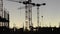 Time lapse FullHD video of construction cranes and workers silhouettes