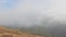 Time-lapse grey clouds passing at mountain peak