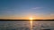 Time-lapse of lake surface at sundown, low-angle, static shot, lens flare