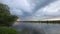 Time-lapse landscape of beautiful dramatic clouds floating over a small river in the spring