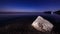 Time lapse. A large stone on the shores of the Black Sea on a starry night. The stars are moving on the horizon. Blue and purple s