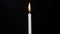 Time lapse of long isolated candle burning with black background