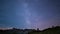 Time Lapse of the Milky way and the starry sky rotating over the majestic Italian French Alps in summertime, illuminated by the mo