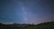 Time Lapse of the Milky way and the starry sky rotating over the majestic Italian French Alps in summertime, illuminated by the mo