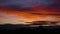 Time lapse of orange sunset. Dark blue clouds floats by golden sky