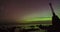 Time lapse pan of Aurora Borealis on a rocky seaside