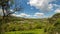 Time lapse panorama green grass, hills, mountain with moving clouds. 4K