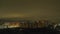 Time-lapse of a panoramic view of a distant neighborhood at night