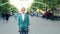 Time lapse portrait of serious young woman standing in city street among crowd