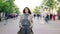 Time lapse portrait of young brunette standing in the street alone among crowd