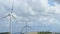 Time-lapse of propellers spinning on wind farm, stormy weather, cloudy sky