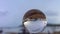 Time lapse raining on crystal ball on the beach.