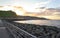 Time lapse of seashore at sunset. Seascape with sun rising while clouds pass by and waves crash in the sand