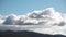 Time lapse serene blue sky with fluffy clouds rolling over the mountains and thick vegetation shot in Tasmania, Australia