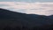 Time lapse serene blue sky with fluffy clouds rolling over the mountains and thick vegetation shot in Tasmania, Australia