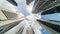 Time-lapse of skyscraper buildings in business district, Singapore city. Cloud on sunny day sky. Low angle view, zoom out