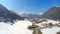 Time lapse of small Alpine resort town at lakeside, huge mountains, snowy peaks