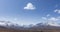 Time lapse of sun movement on crystal clear sky with clouds over snow mountain top. Yellow grass at autumn high altitude