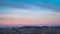 Time lapse sunrise: famous Barolo wineyards in winter, medieval village perched on hill top, snow capped Alps mountain range on th