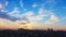 Time-lapse, sunset and moving clouds, beautiful skyscape above town at dusk