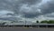 Time-lapse of an urban empty retail building and clouds with a man cleaning the parking lot