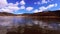 Time lapse video of clouds moving in the blue sky with reflections in the water