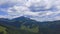 Time lapse video of summer mountain, aerial video of forest and rocky mountain with moving clouds