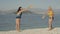 Time-lapse video of two beautiful girls playing tennis on the beach by the sea.