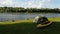 Time Lapse view of the tent and yellow kayak on the shore river. Small clouds on the horizon.