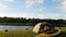 Time Lapse view of the tent and yellow kayak on the shore river. Small clouds on the horizon.